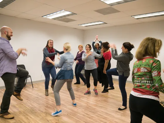 Improv students mid-exercise in a bright classroom