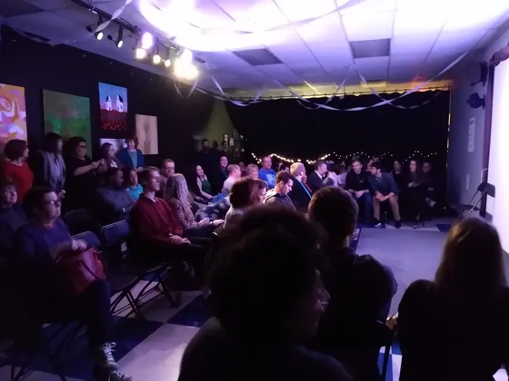 A full audience watching a show under stage lights