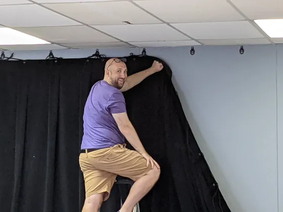 Volunteer hanging black stage curtains