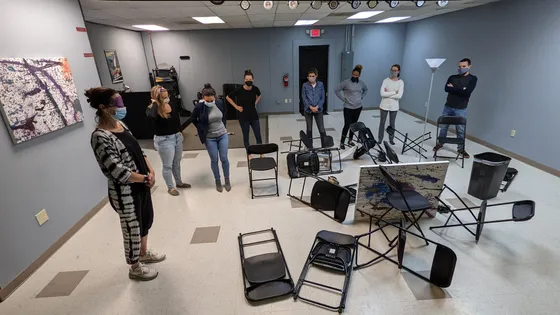 Students gathered for a class in a room of folding chairs